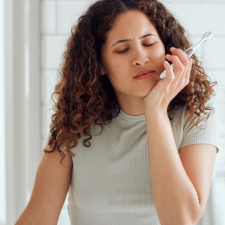 Vrouw heeft last van gevoelige tanden tijdens het poetsen