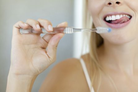 vrouw poetst haar tanden om aften te voorkomen